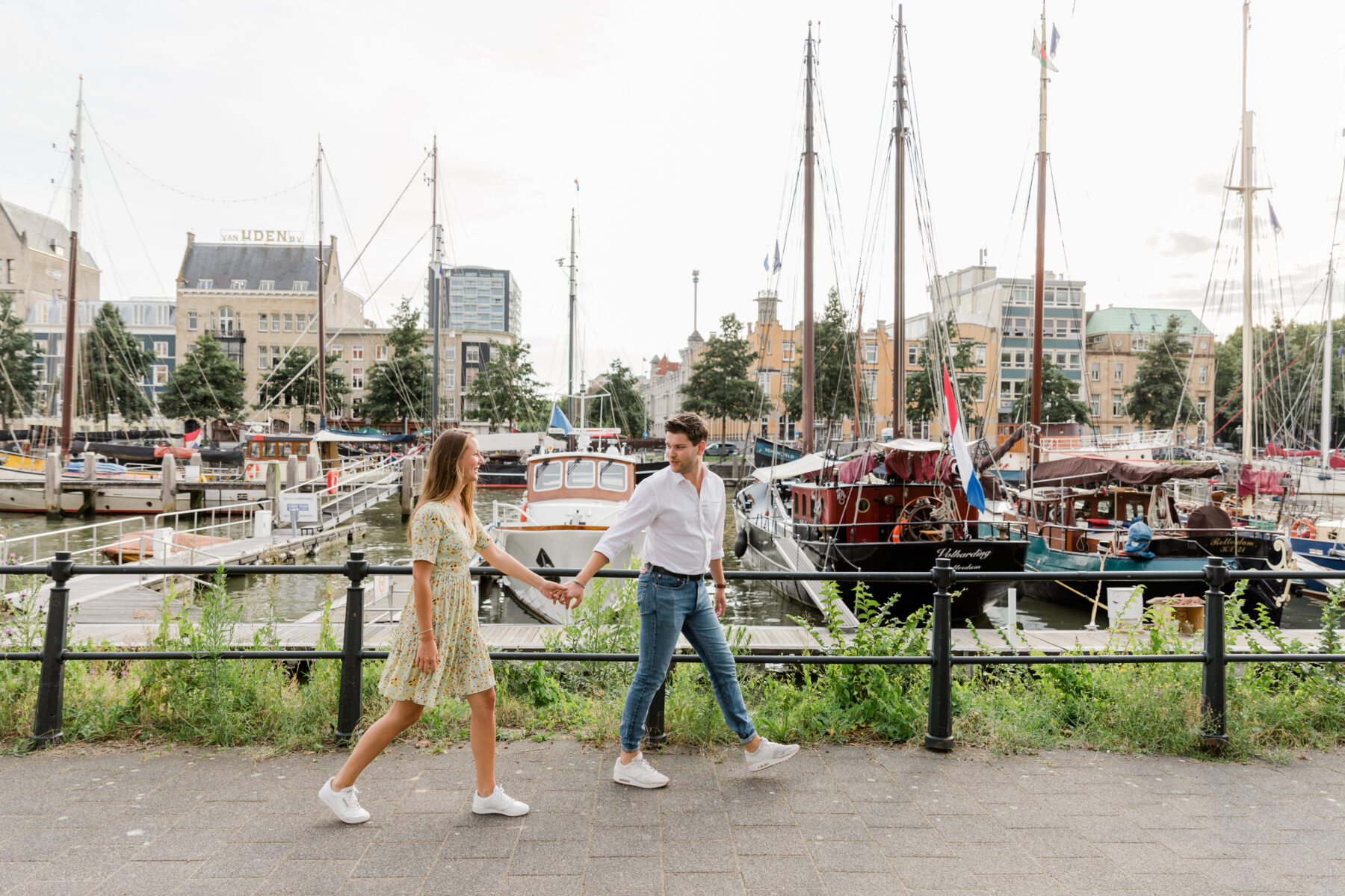 Koppel loopt hand in hand langs haven.