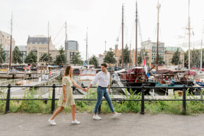 Koppel loopt hand in hand langs haven.